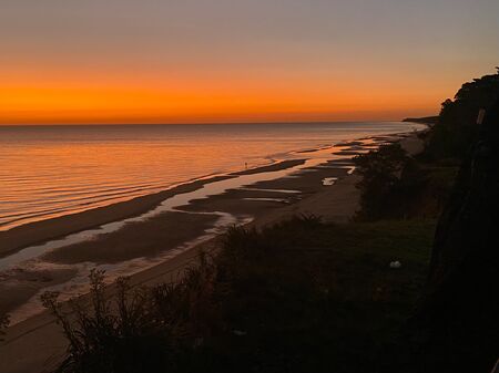 Atemberaubender Sonnenuntergang über dem Meer am Strand in Uruguay. Der Himmel leuchtet in allen Farben.